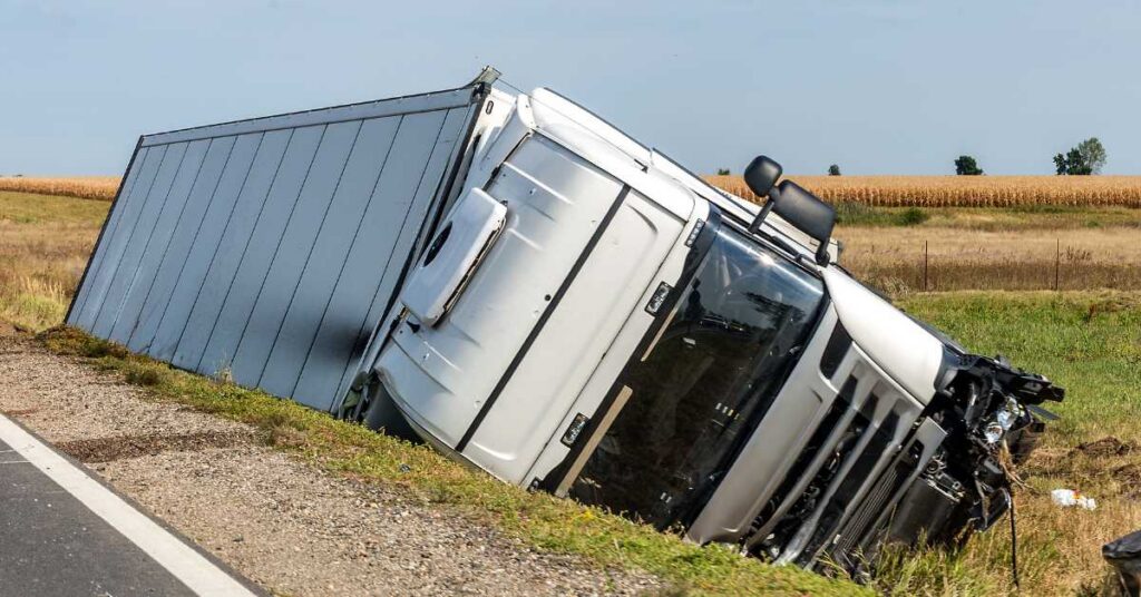 Tractor-trailer on its side on a highway shoulder after a crash, like those on I-80 near Bloomsburg